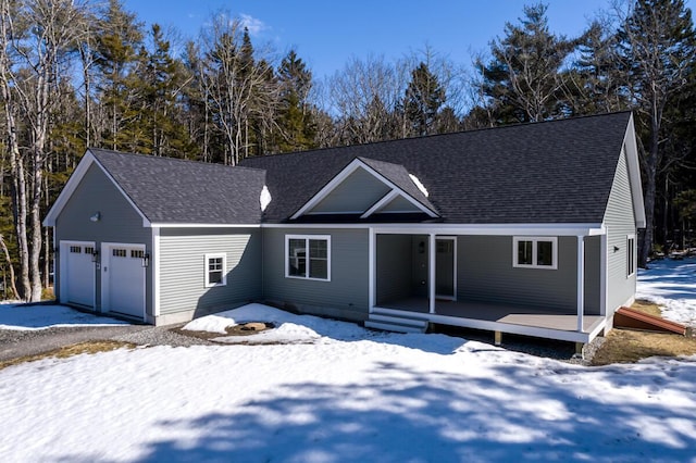 view of front of home with a garage and a shingled roof