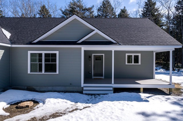 view of front facade featuring covered porch and a shingled roof