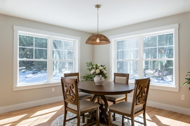 dining space with baseboards and light wood finished floors