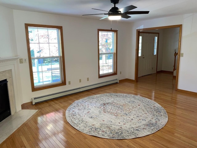 entrance foyer featuring a premium fireplace, wood finished floors, a ceiling fan, and baseboard heating