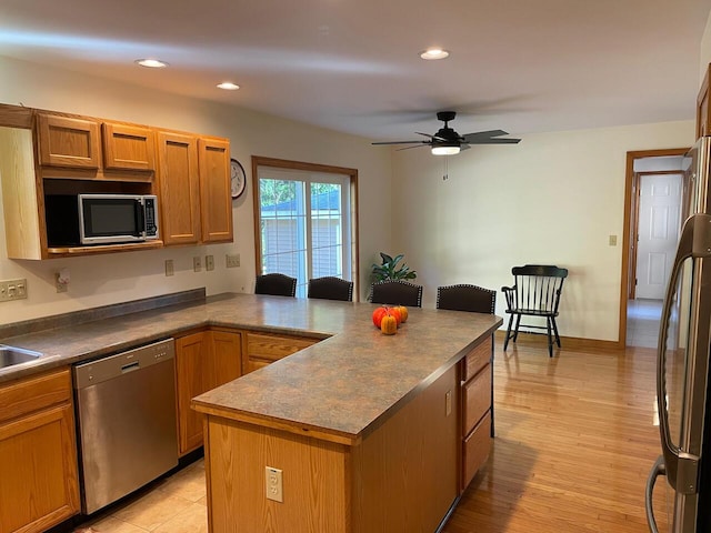 kitchen featuring ceiling fan, a peninsula, appliances with stainless steel finishes, and recessed lighting