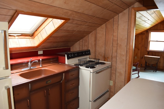 kitchen with wooden walls, lofted ceiling with skylight, white appliances, and wood ceiling