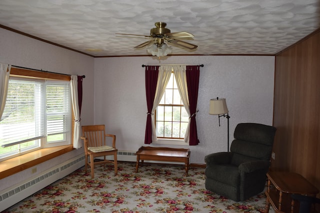 living area with crown molding, a textured ceiling, baseboard heating, and ceiling fan