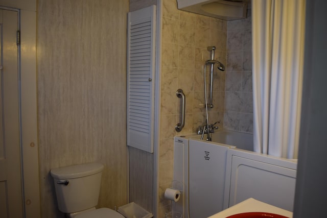 bathroom featuring shower / bath combo with shower curtain and toilet