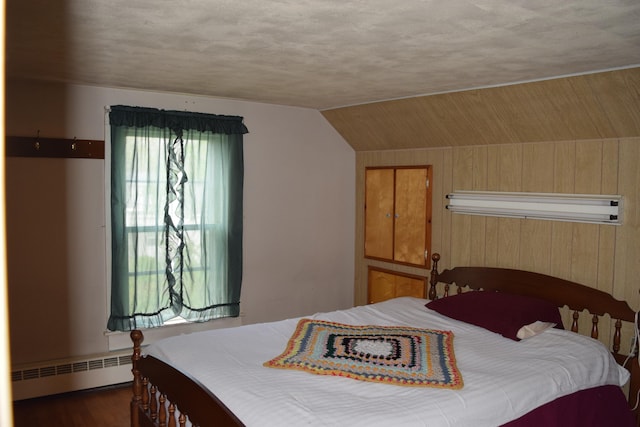 bedroom with a baseboard radiator, a textured ceiling, vaulted ceiling, and dark hardwood / wood-style flooring