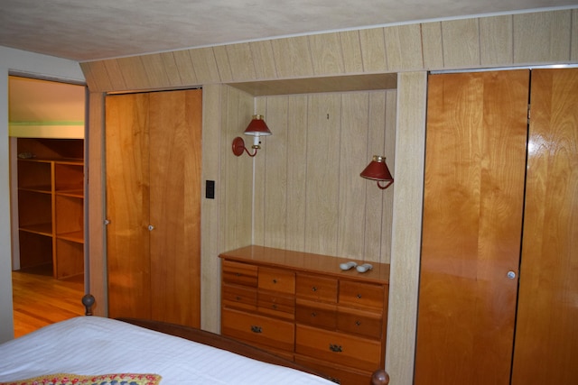 bedroom with wooden walls and wood-type flooring