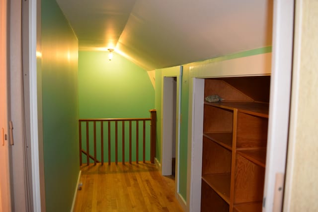 hallway featuring hardwood / wood-style flooring and lofted ceiling