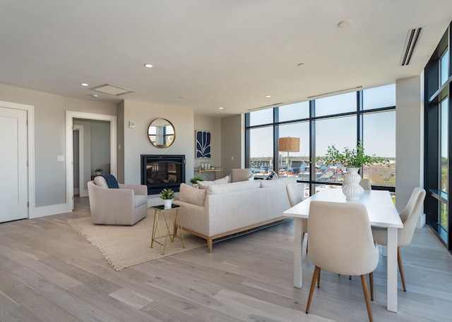 387 Commercial St Unit 709, Portland, ME 04101 - living area with a wall of windows, light wood-style flooring, a glass covered fireplace, and recessed lighting