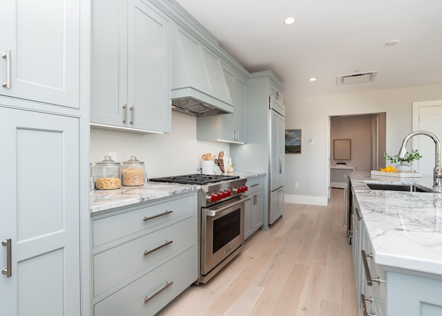 387 Commercial St Unit 709, Portland, ME 04101 - kitchen featuring a sink, premium appliances, custom range hood, light wood finished floors, and recessed lighting