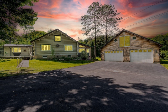 log-style house with a garage, a yard, and an outdoor structure