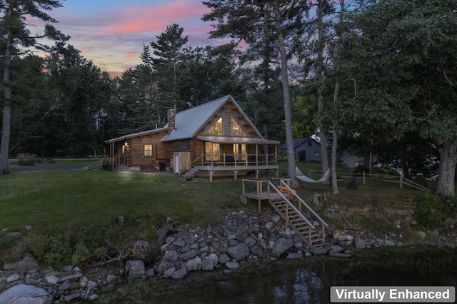 114 Fort Rd, Edgecomb, ME 04556 - back of property at dusk featuring a yard, a chimney, metal roof, log exterior, and a wooden deck