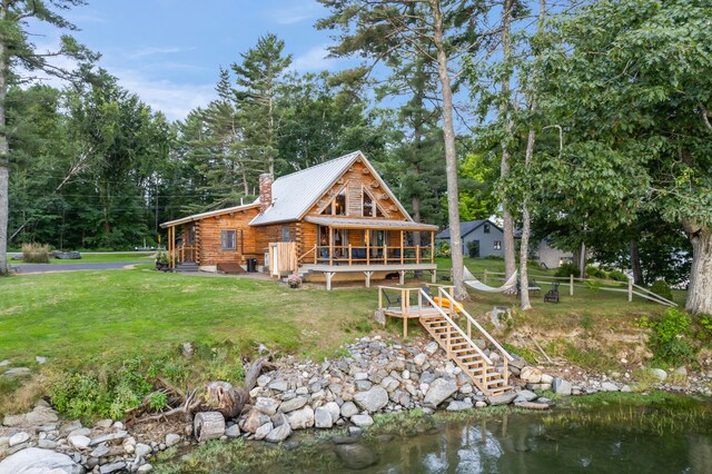 back of house featuring a water view and a yard