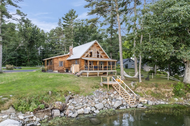 114 Fort Rd, Edgecomb, ME 04556 - back of house with metal roof, a yard, log siding, a wooden deck, and a chimney