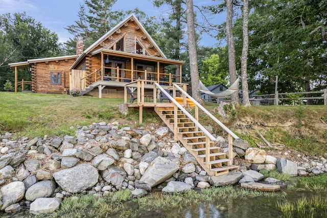 114 Fort Rd, Edgecomb, ME 04556 - view of front of house with log exterior, a front lawn, stairway, and a chimney