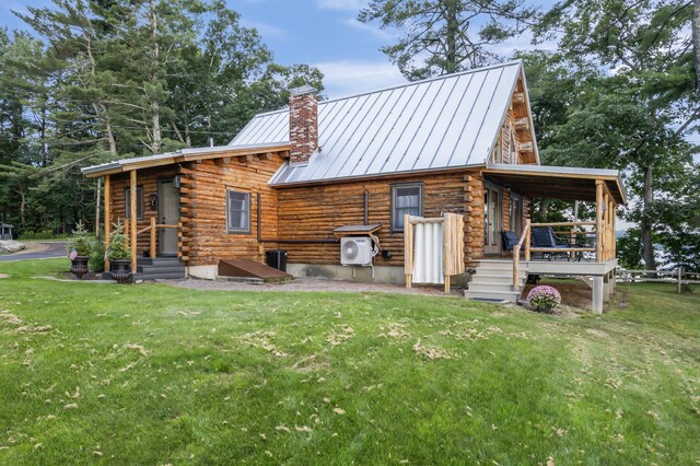 rear view of property featuring ac unit and a lawn