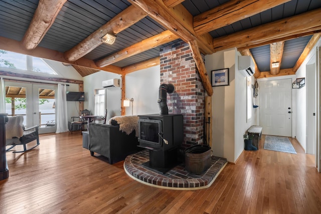 114 Fort Rd, Edgecomb, ME 04556 - living room with a wood stove, a wall unit AC, hardwood / wood-style floors, and french doors