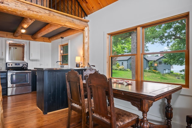 dining room featuring hardwood / wood-style floors, vaulted ceiling with beams, and wooden ceiling