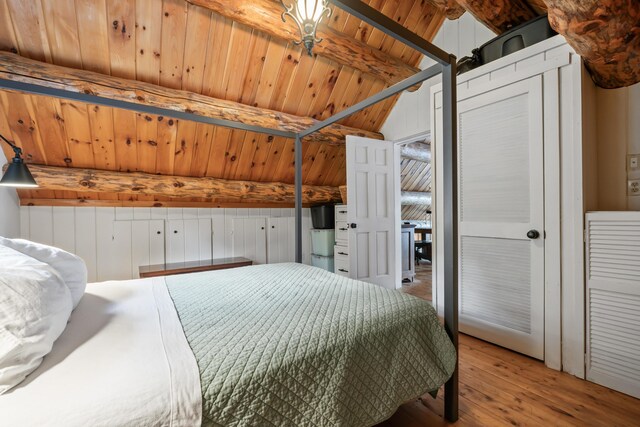 bedroom featuring wood ceiling, light hardwood / wood-style floors, and lofted ceiling with beams