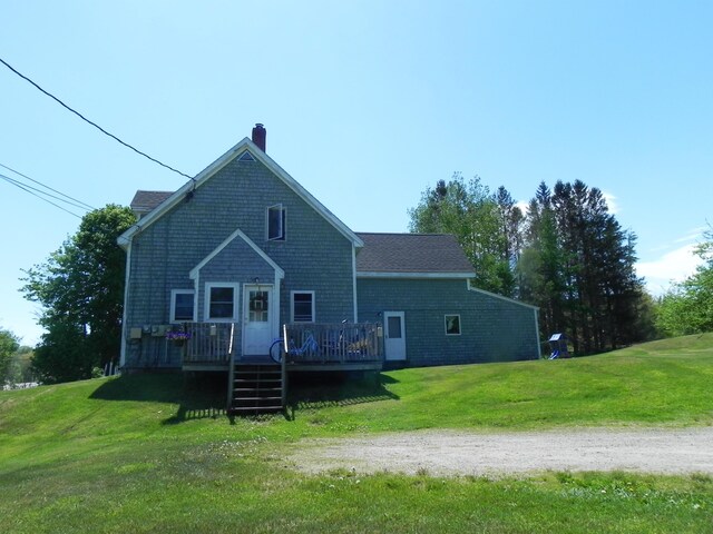 view of front of home with a wooden deck and a front lawn