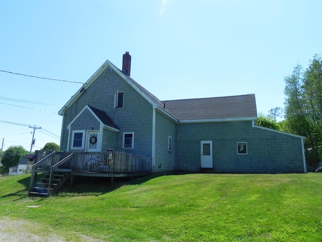 back of property with a deck and a yard