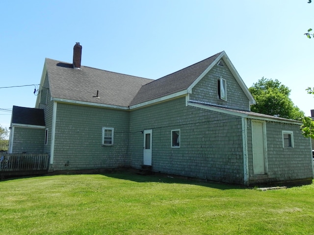 rear view of house featuring a yard