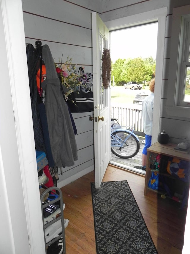 entryway with hardwood / wood-style floors and wooden walls