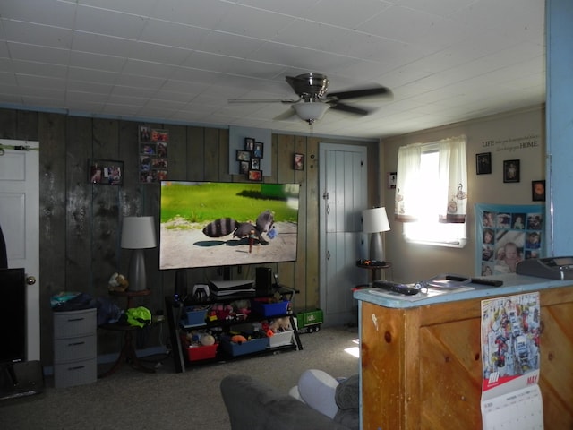 kitchen with ceiling fan, wooden walls, and carpet flooring