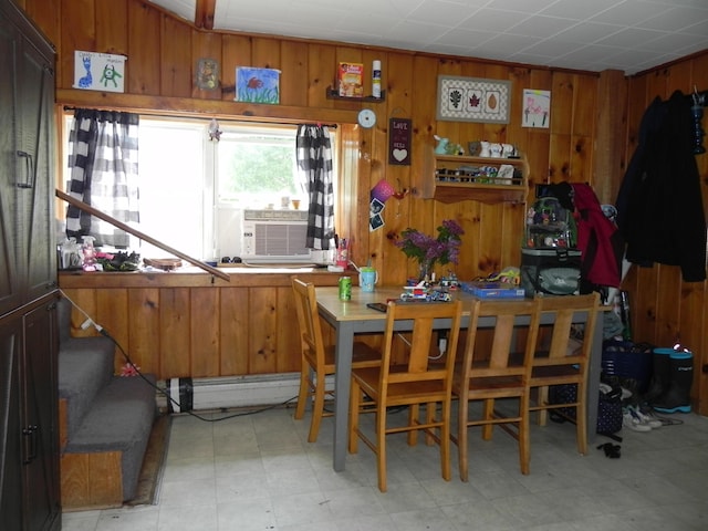 dining space featuring cooling unit and wood walls