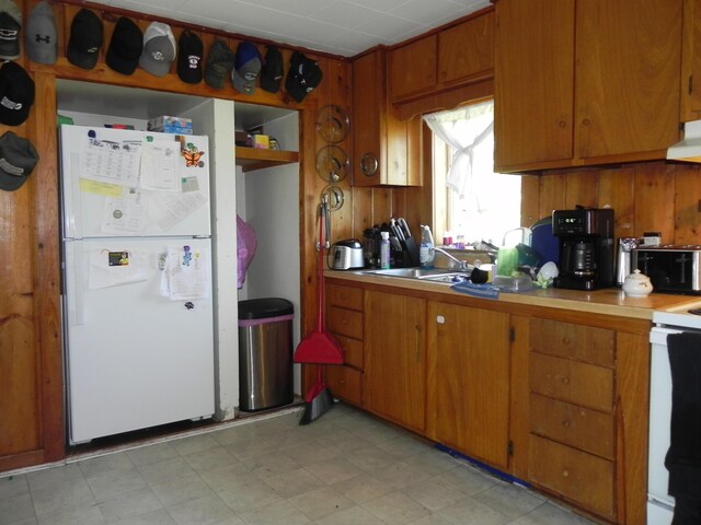 kitchen with stove, white refrigerator, and sink