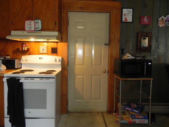 kitchen featuring electric stove and wood walls