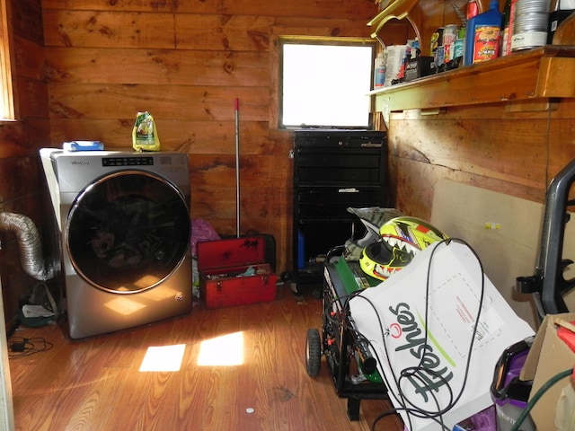 washroom with hardwood / wood-style flooring, washer / dryer, and wooden walls