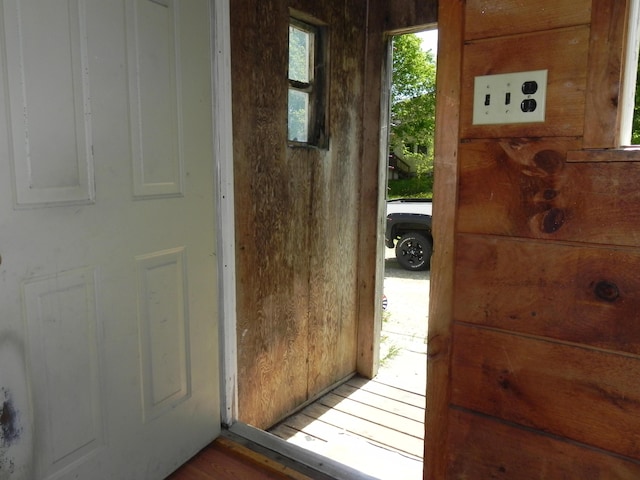 doorway to outside featuring wooden walls