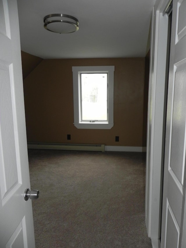unfurnished room with a baseboard heating unit, baseboards, carpet floors, and lofted ceiling