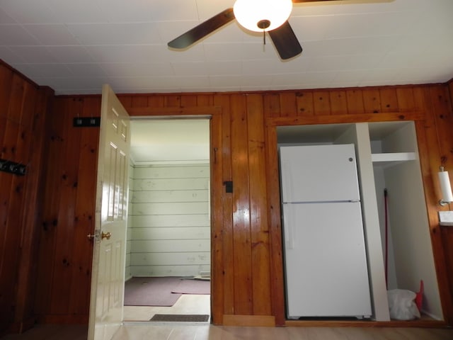 interior space featuring wooden walls and a ceiling fan