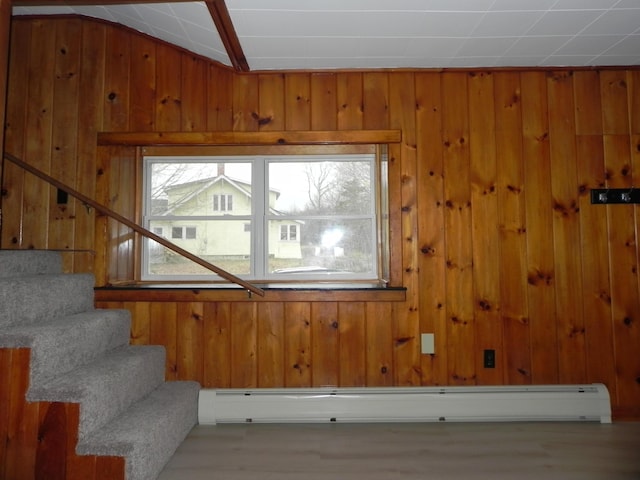 stairs featuring wood finished floors and wooden walls