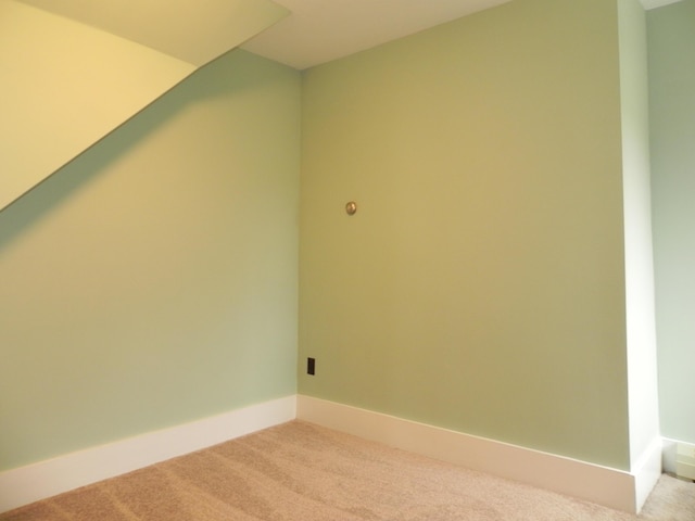 bonus room with light colored carpet and baseboards