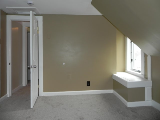 bonus room featuring light carpet and baseboards
