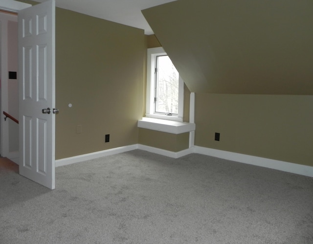 additional living space featuring vaulted ceiling, baseboards, and carpet