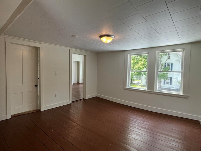 spare room featuring dark wood-type flooring