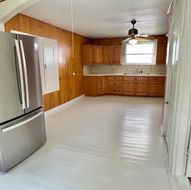 kitchen with decorative backsplash, light hardwood / wood-style flooring, stainless steel refrigerator, and ceiling fan