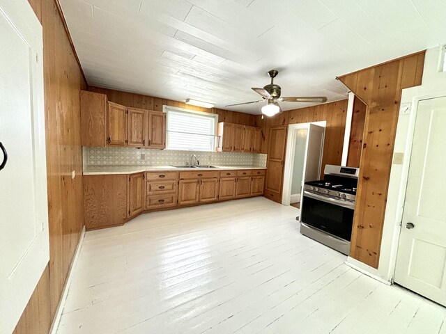 kitchen with stainless steel range, tasteful backsplash, sink, and ceiling fan