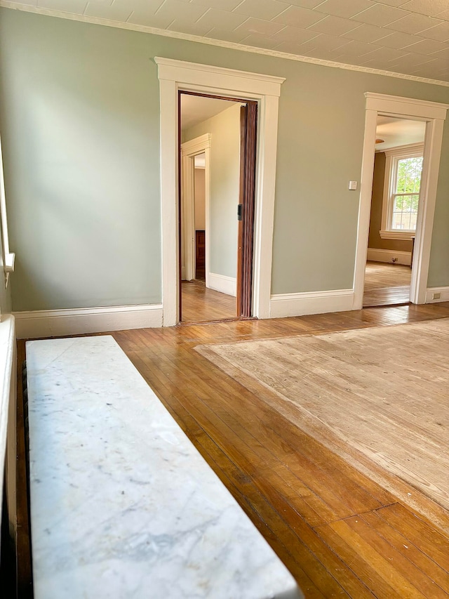 spare room featuring hardwood / wood-style flooring and ornamental molding