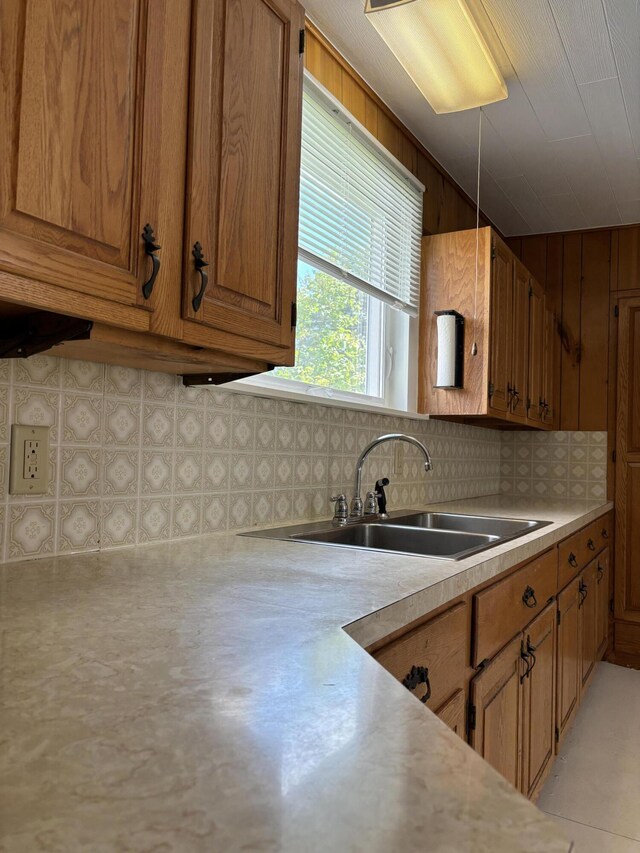 kitchen with tasteful backsplash, sink, and wooden walls