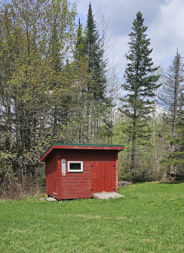 view of outbuilding with a yard