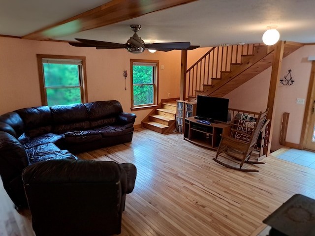 living room featuring ceiling fan, beamed ceiling, and light wood-type flooring