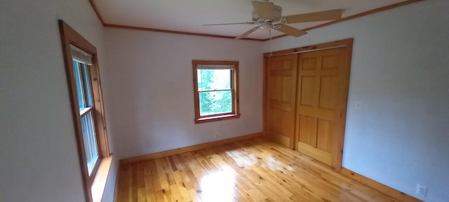 unfurnished bedroom with a closet, ceiling fan, crown molding, and light wood-type flooring