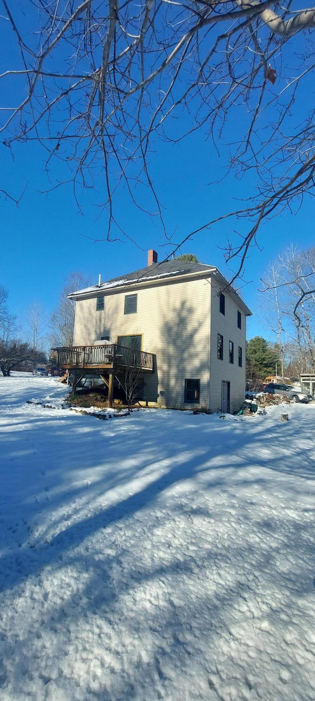 snow covered property featuring a wooden deck