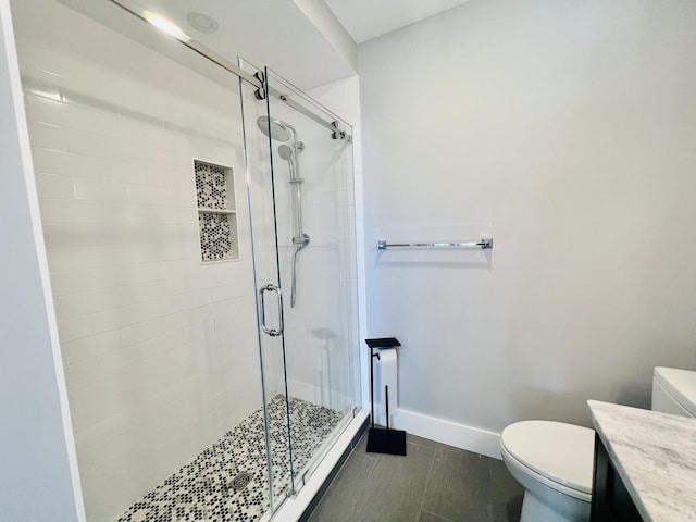 bathroom featuring an enclosed shower, vanity, wood-type flooring, and toilet