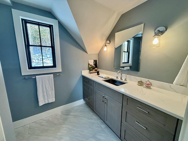 bathroom featuring vaulted ceiling and vanity