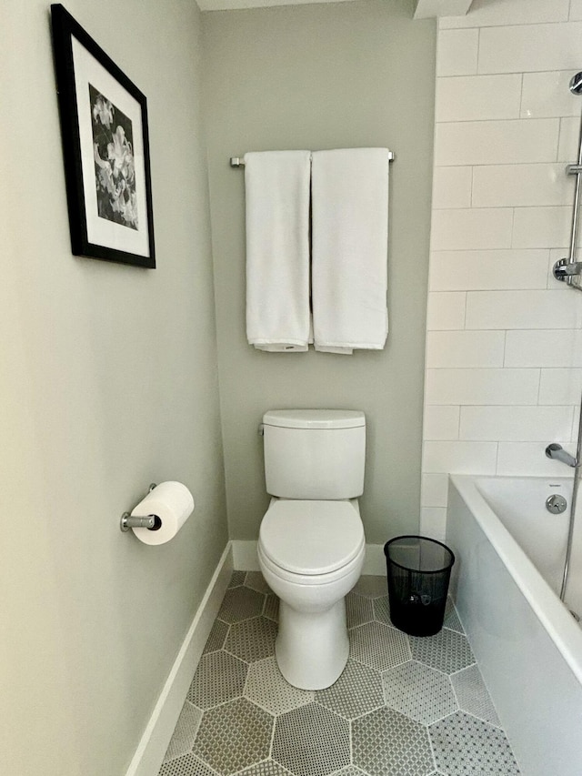 bathroom featuring tiled shower / bath, tile patterned floors, and toilet